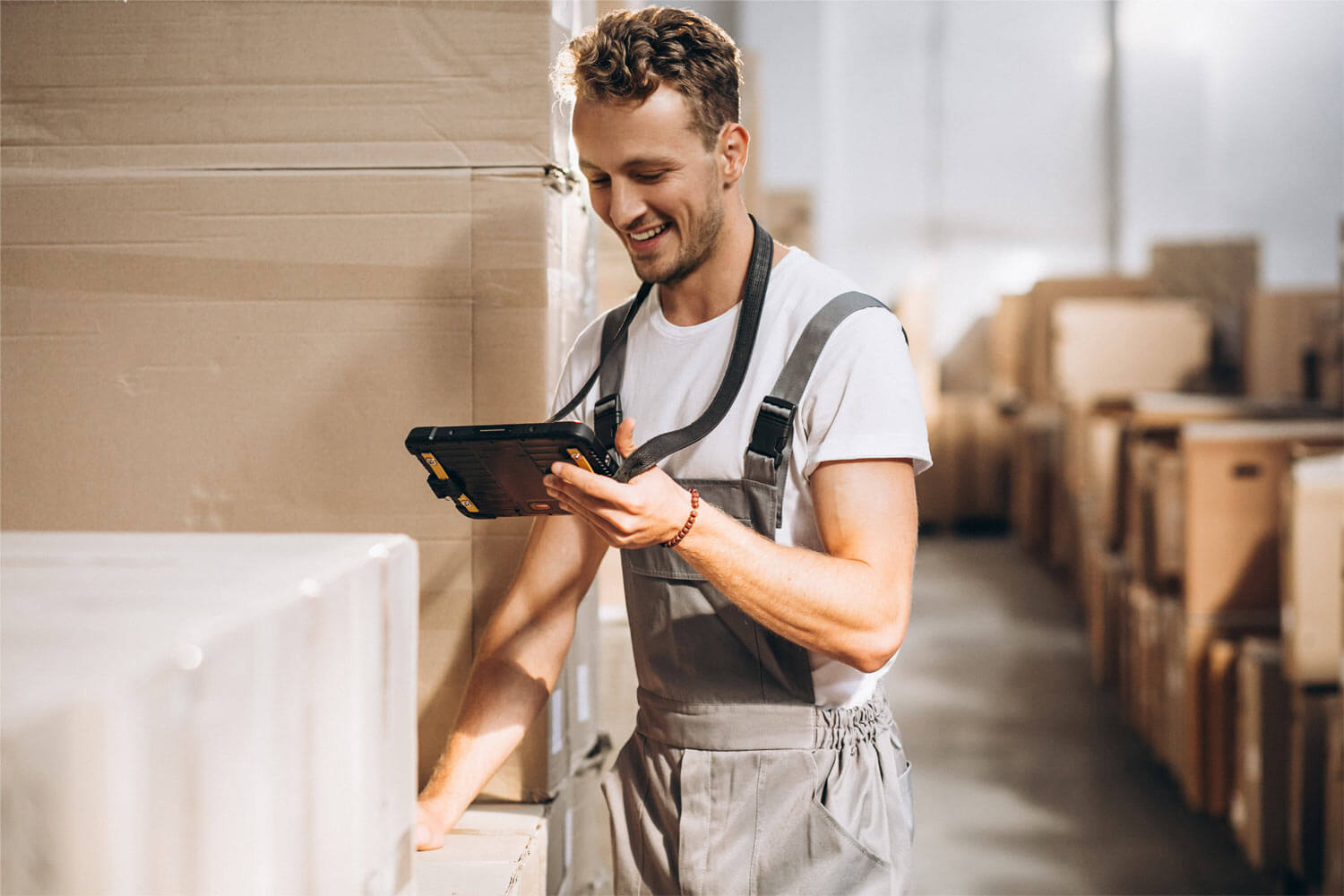 Mann verwaltet mit SAP Business One digital ein Lager an einem Handheld