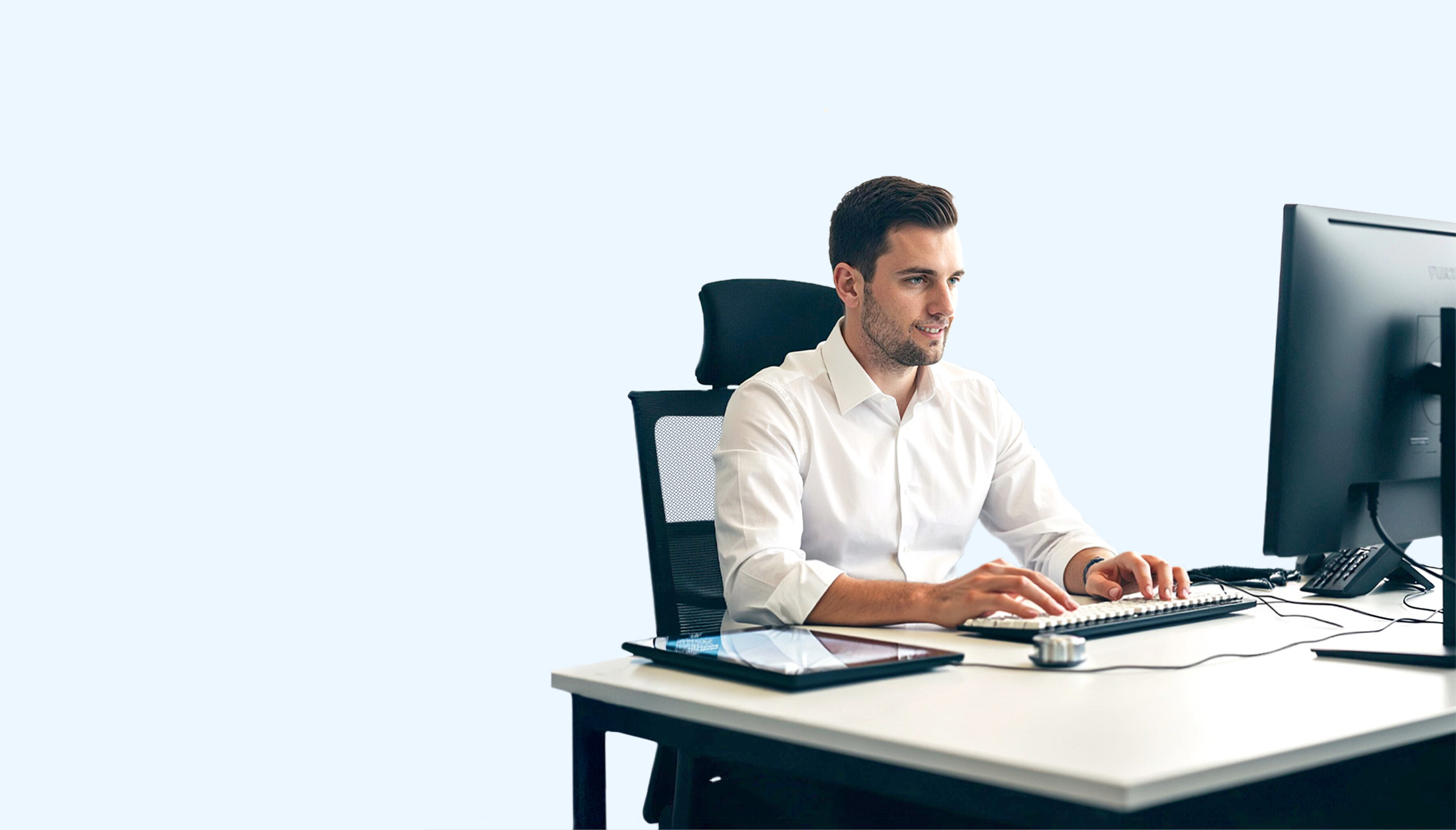 Ein Mann arbeitet im Einkauf mit SAP Business One an einem PC und Tablet.