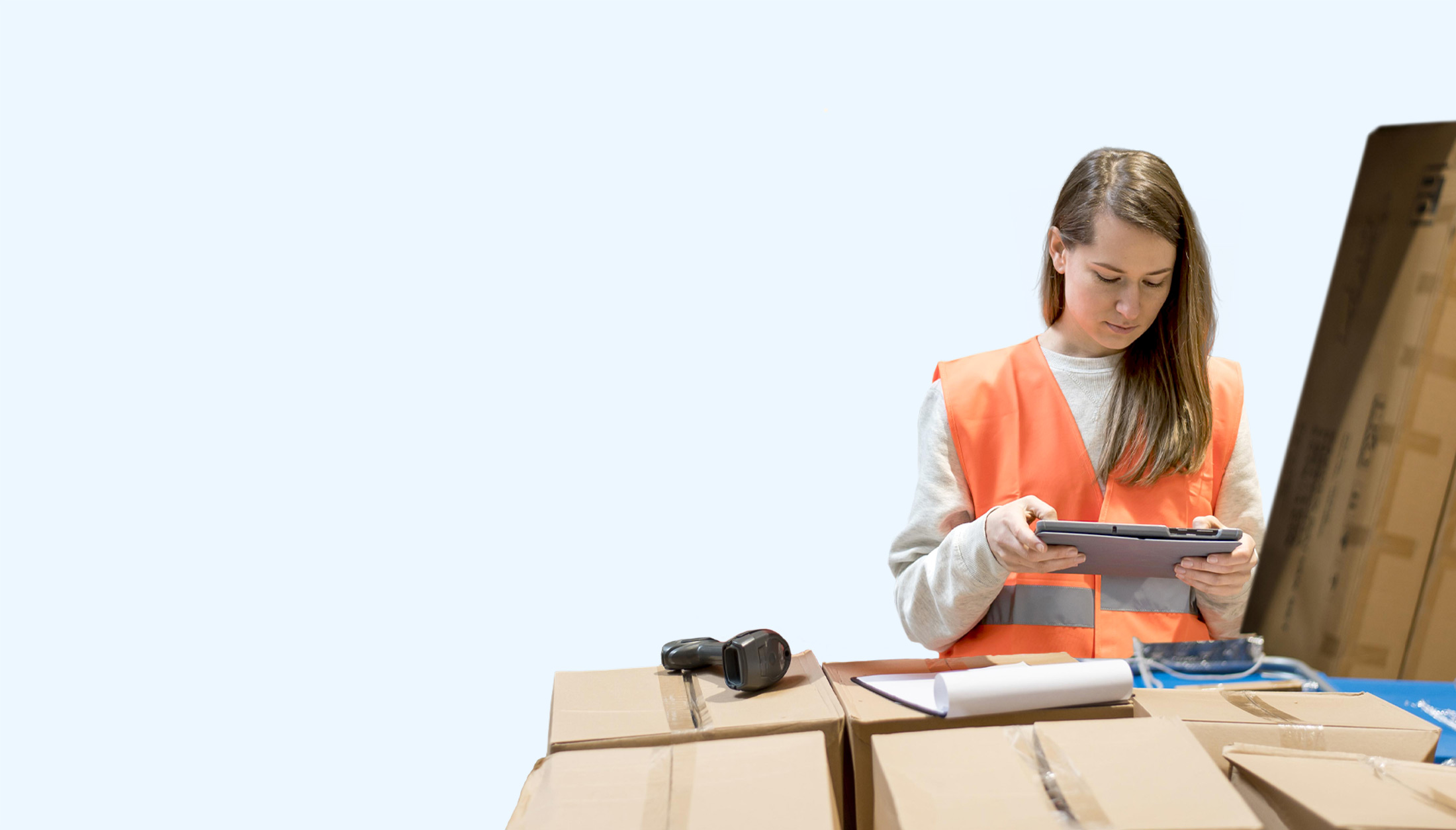 Eine Frau im Lager arbeitet mit einem Tablet und einem Barcode-Scanner mit der SAP Business One Warenwirtschaft.